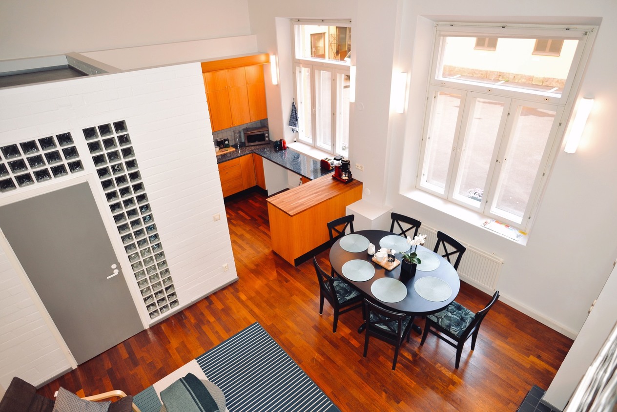 Fully equipped kitchen and dining area with round table in a 5-person apartment at Hostel Diana Park Helsinki