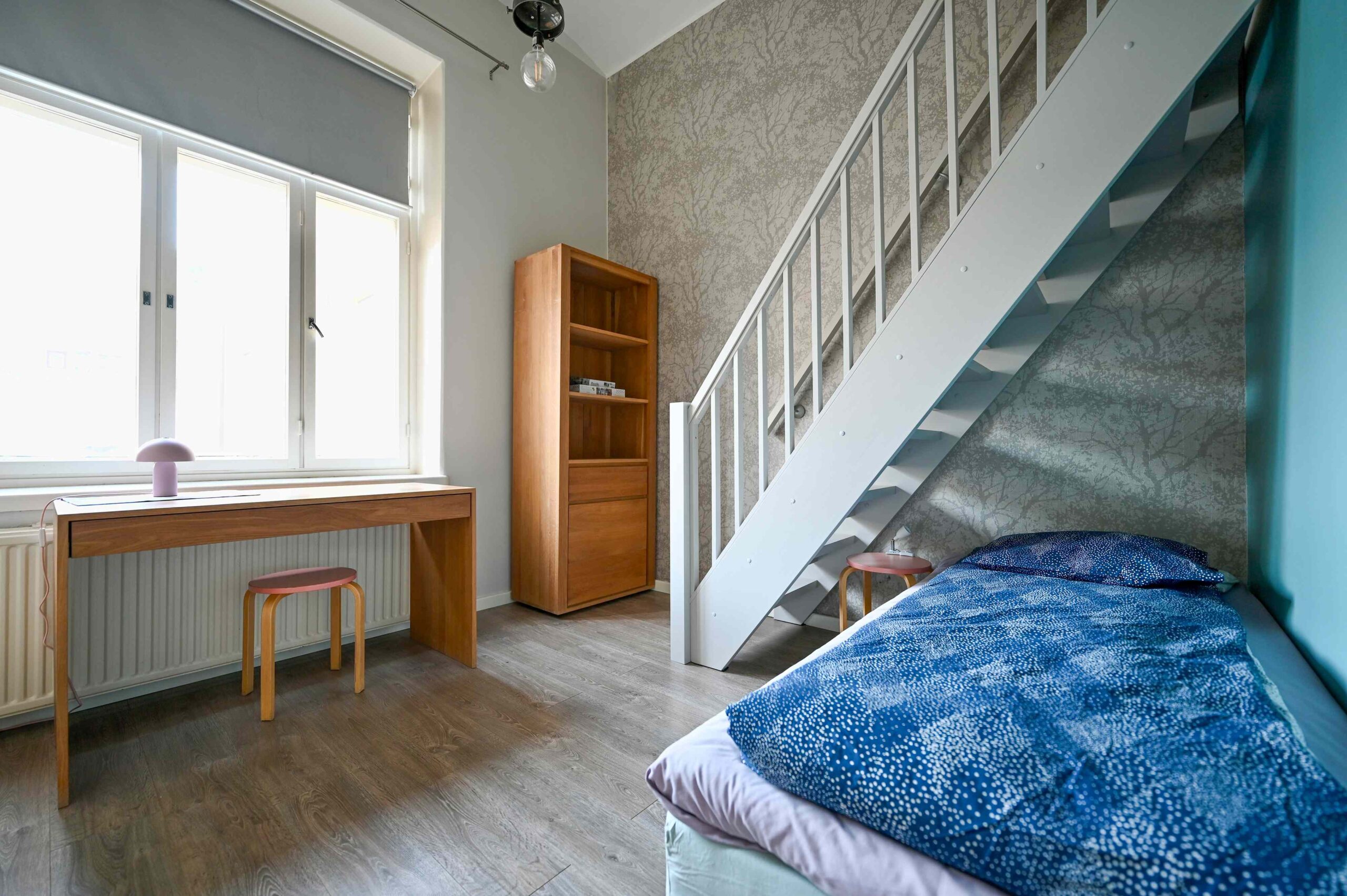 Apartment bedroom featuring a single bed and a king-size loft bed at Hostel Diana Park Helsinki