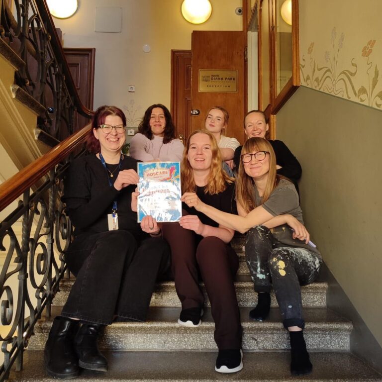 Hostel Diana Park staff team smiling together on the staircase in Helsinki